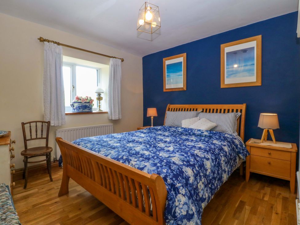 A bedroom with a bed and nightstand at Pen Glorian in Conwy