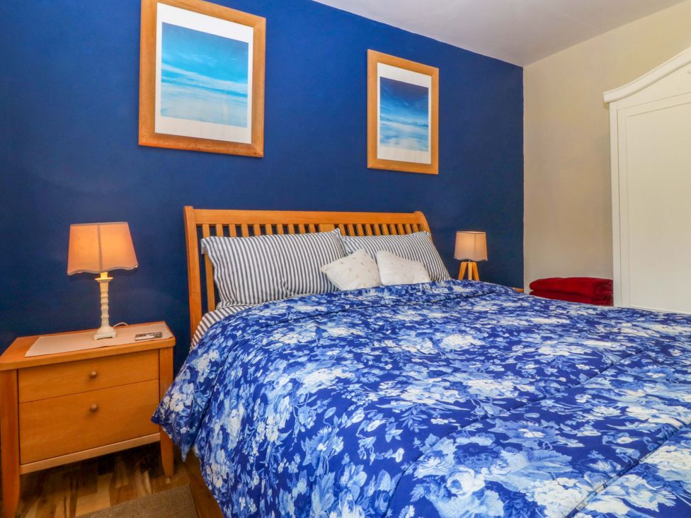 A bedroom with a bed and bedside tables at Pen Glorian in Conwy
