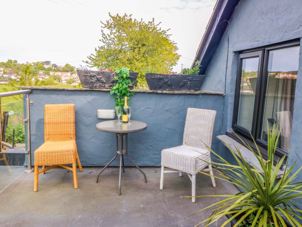 A balcony with two chairs and a table at Pen Glorian in Conwy