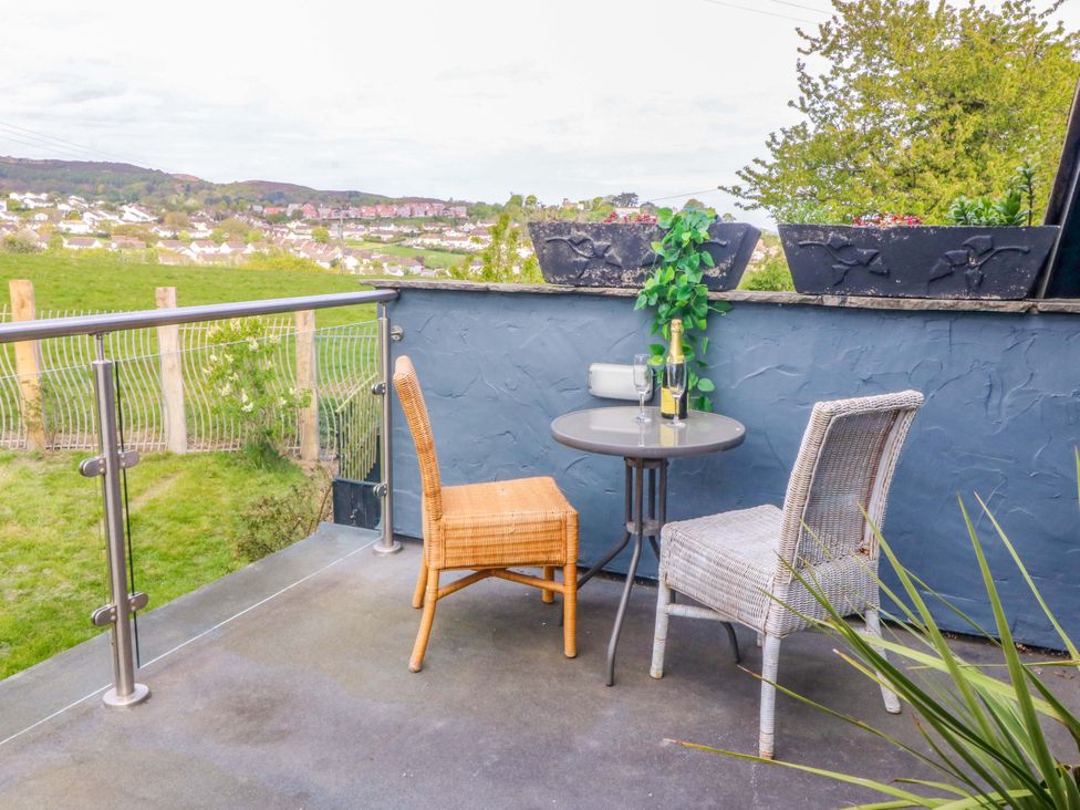 A patio area with a table and chairs at Pen Glorian in Conwy