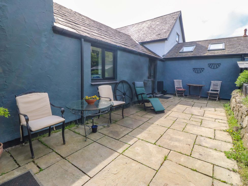 An outdoor patio with chairs and a table at Pen Glorian in Conwy