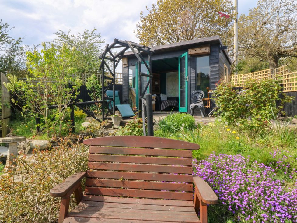 A garden with a bench and a shed at Pen Glorian in Conwy