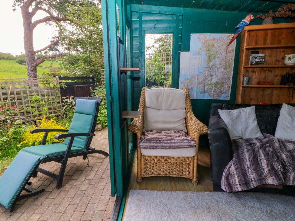 A garden room with chairs and a map on the wall at Pen Glorian in Conwy