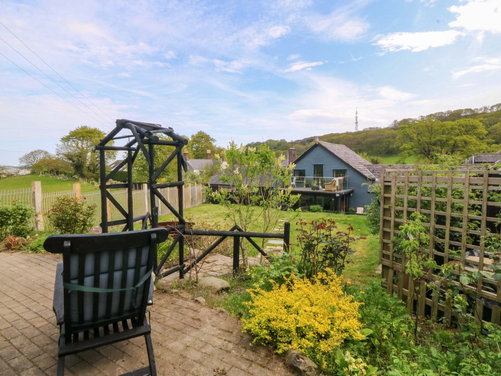 A garden with a chair and plants at Pen Glorian in Conwy
