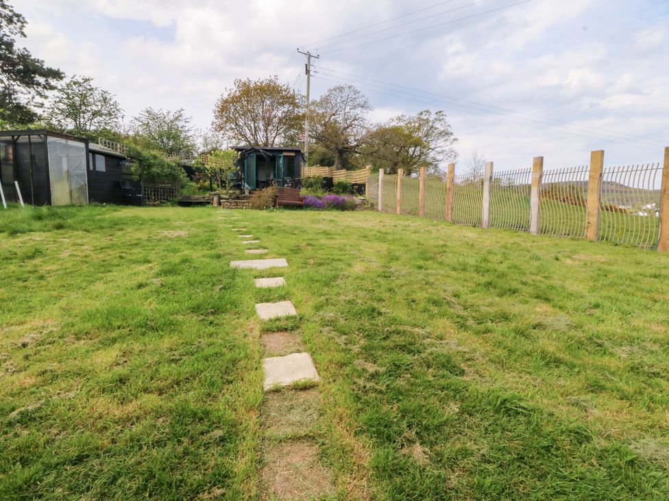 A garden with a stone path leading to a shed at Pen Glorian in Conwy