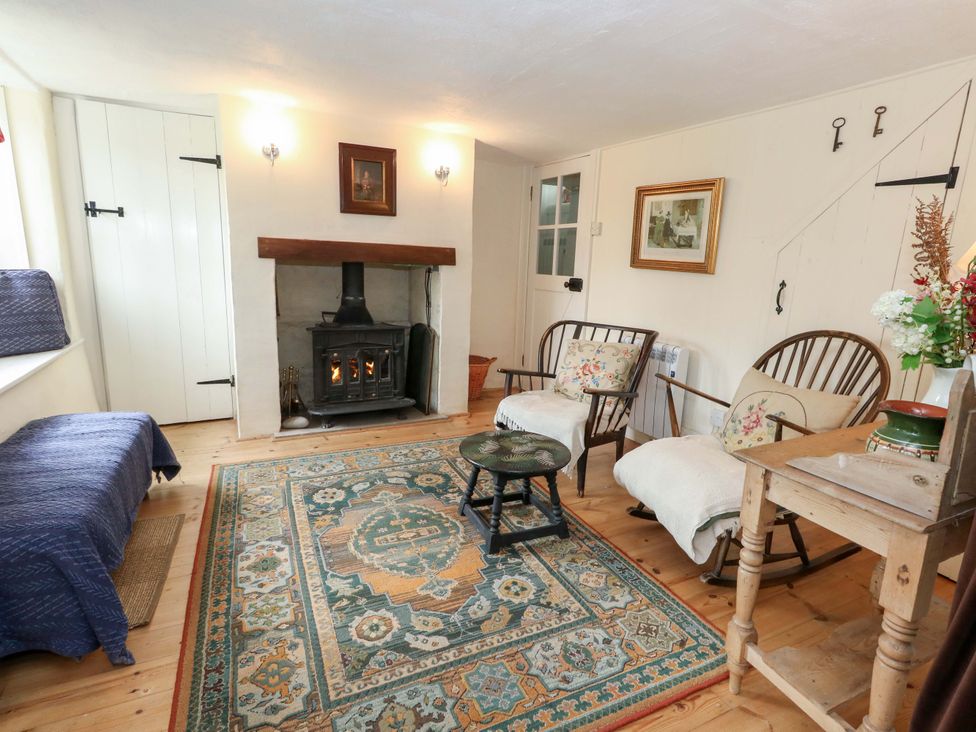 A living room with a fireplace and seating area at Little Orchard in Chard