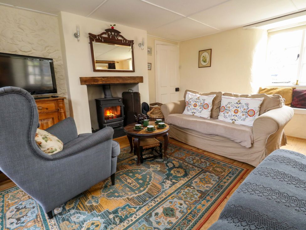 A living room with a sofa and armchair at Little Orchard in Chard