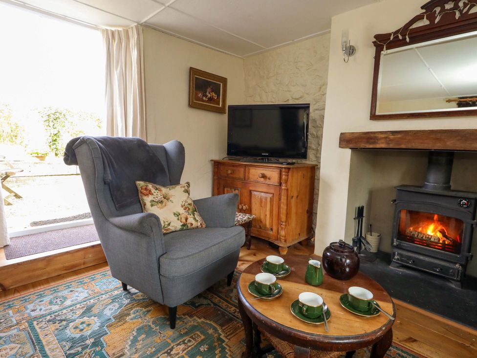 A living room with an armchair and a coffee table at Little Orchard in Chard