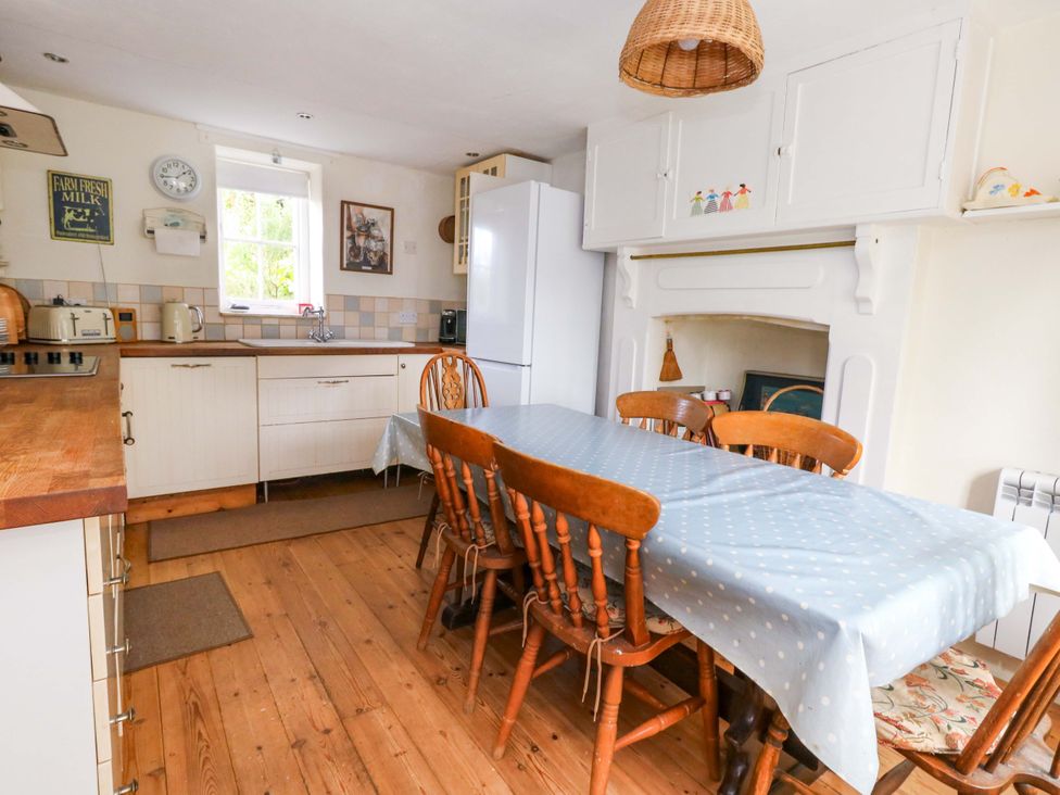A kitchen with a dining table and chairs at Little Orchard in Chard