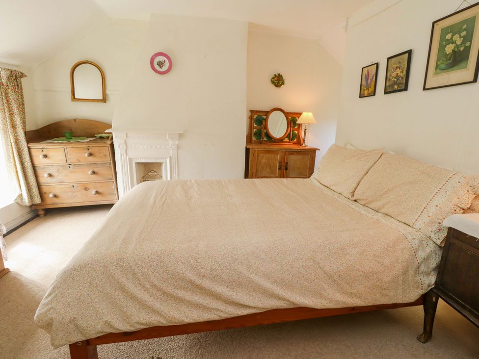 A bedroom featuring a bed, a drawer chest, and decorative wall art at Little Orchard in Chard