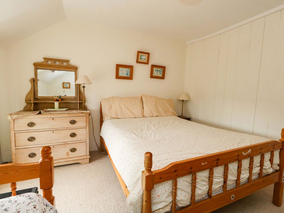 A bedroom with a bed and dresser at Little Orchard in Chard