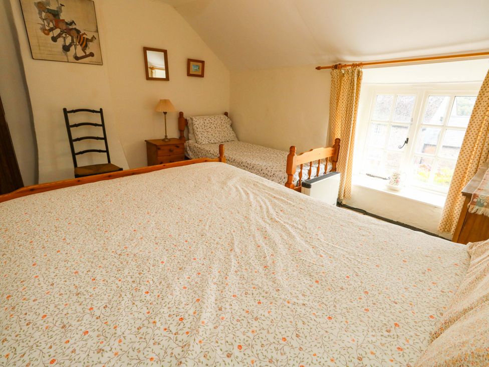 A bedroom with a double bed and single bed at Little Orchard in Chard