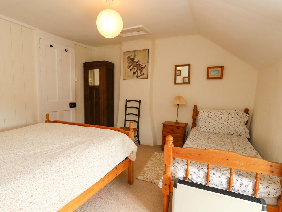 A bedroom with two beds, a lamp and artwork at Little Orchard in Chard