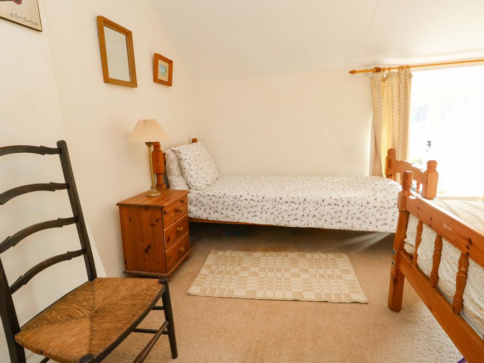 A bedroom with two beds and a lamp at Little Orchard in Chard