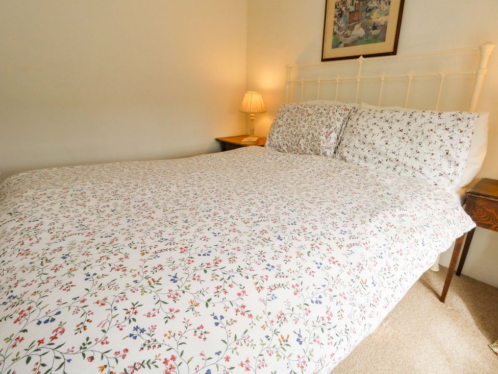 A bedroom with a bed and nightstand at Little Orchard in Chard