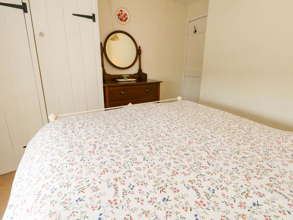 A bedroom with a bed and dressing table at Little Orchard in Chard