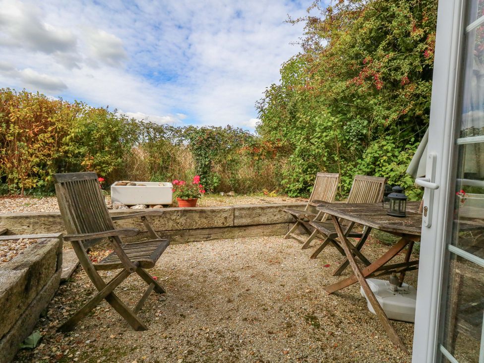 A garden area with a table and chairs at Little Orchard in Chard