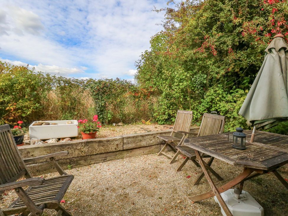 A garden area with a table and chairs at Little Orchard in Chard