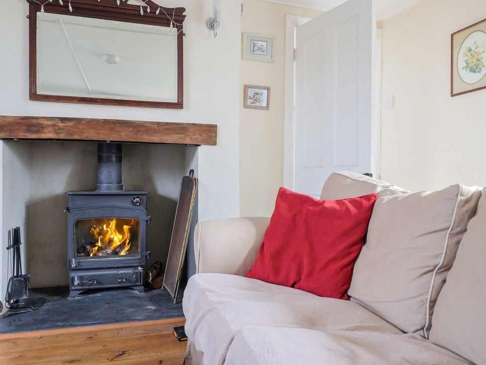 A living room with a fireplace and sofa at Little Orchard Thorncombe Nr. Chard
