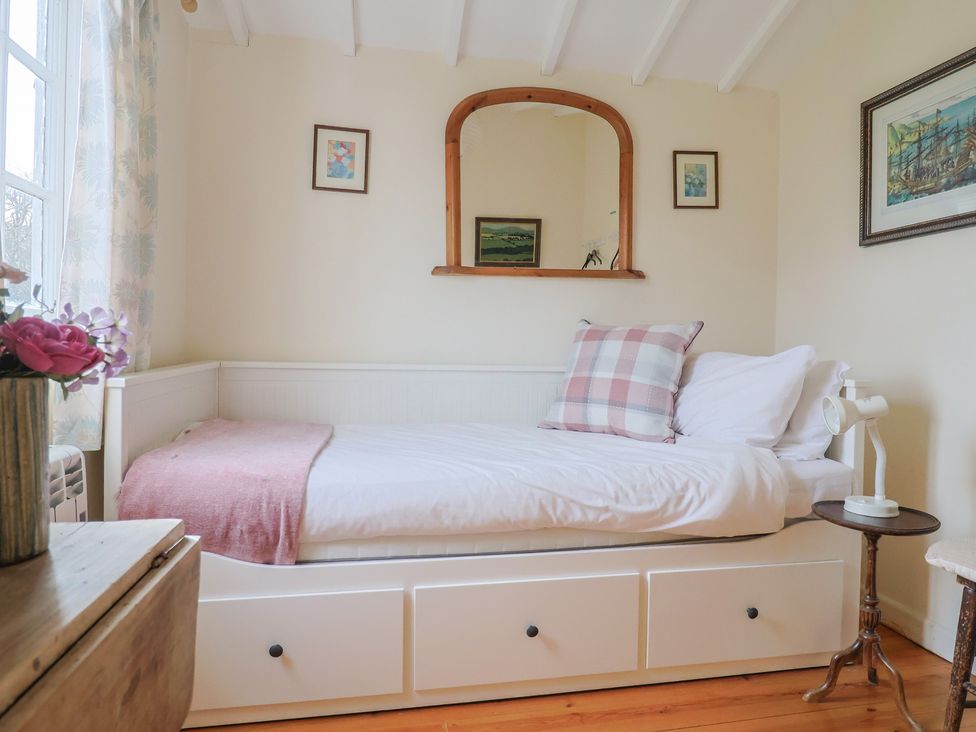 A bedroom with a bed and mirror at Little Orchard Thorncombe Nr. Chard