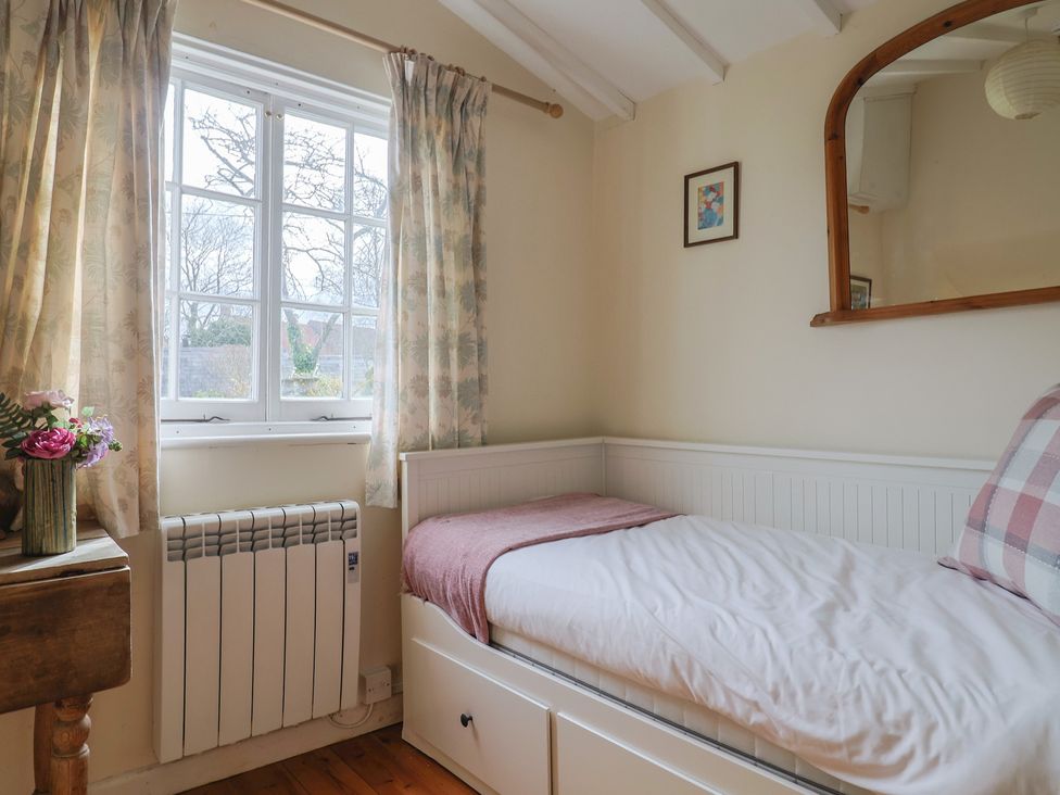 A bedroom with a bed and window at Little Orchard Thorncombe Nr. Chard