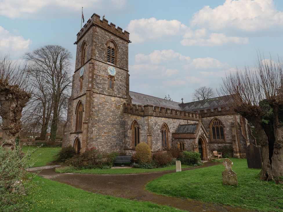 An outdoor view of a church building with a tower and clock at Little Orchard Thorncombe Nr. Chard