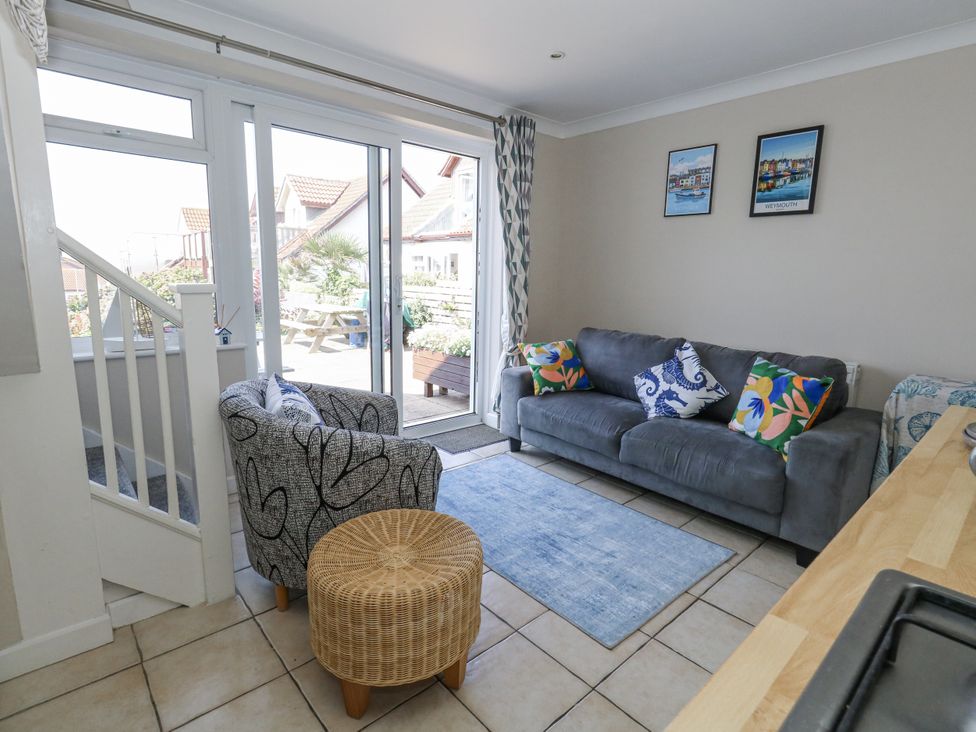 A living room with a sofa and armchair at Sea Spray in Bowleaze