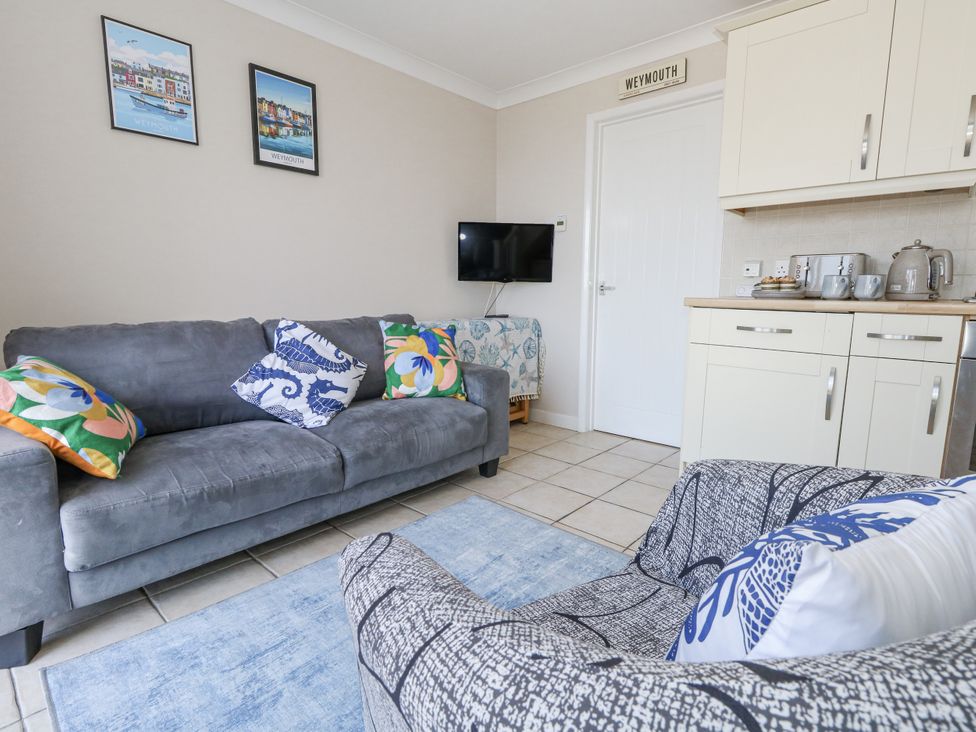 A living room with a sofa and television at Sea Spray Bowleaze