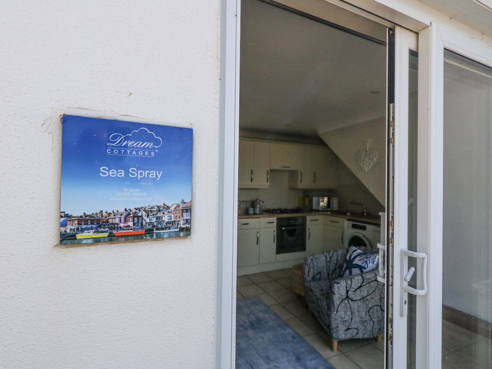 A kitchen with various appliances and a sofa at Sea Spray in Bowleaze