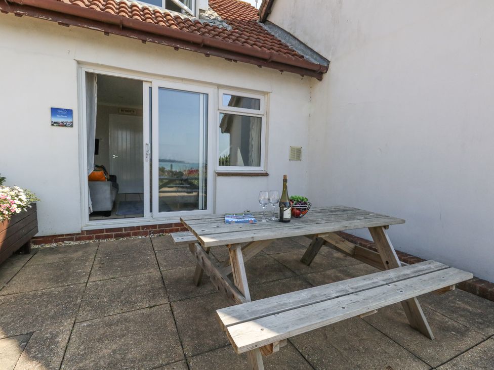 An outdoor seating area with a table and drinks at Sea Spray in Bowleaze