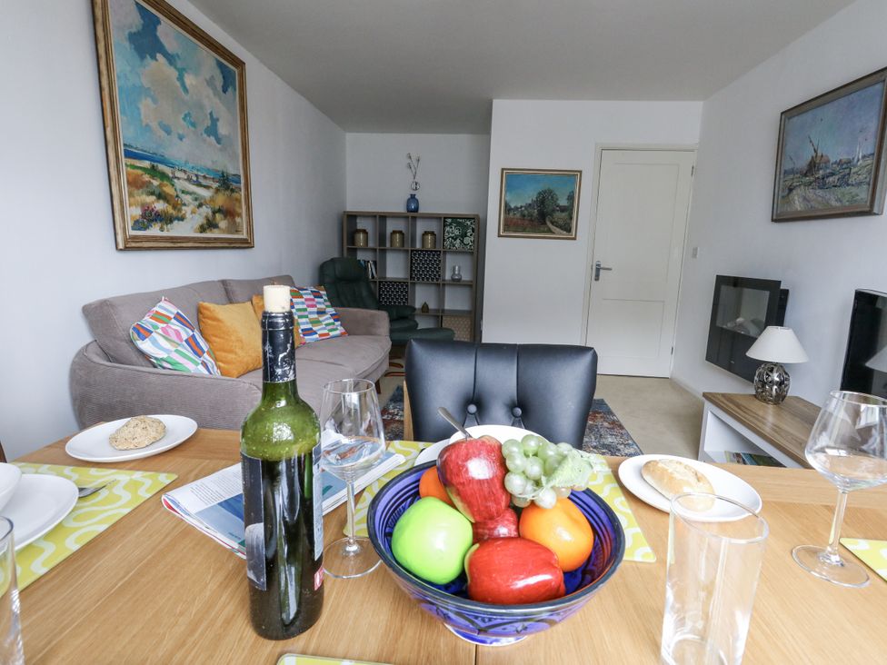 A living room with a fruit bowl and wine bottle at Flat 13, Chesil House in Bridport