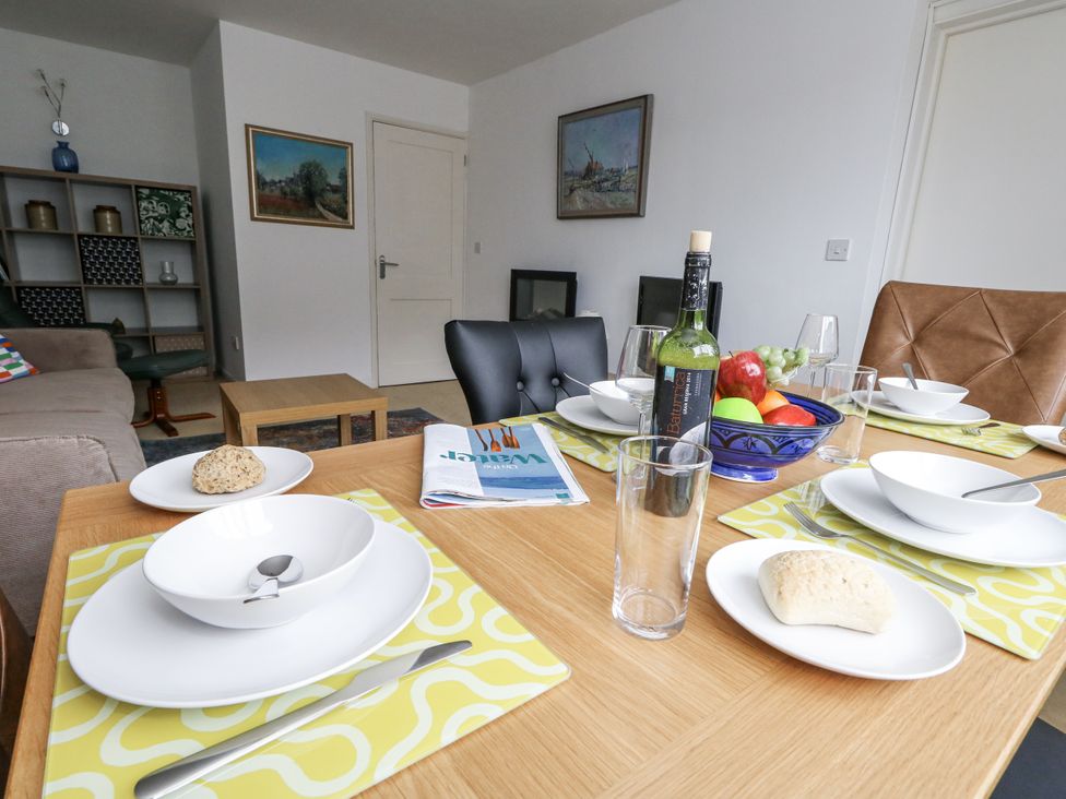 A dining table set with plates and fruit at Flat 13, Chesil House in Bridport
