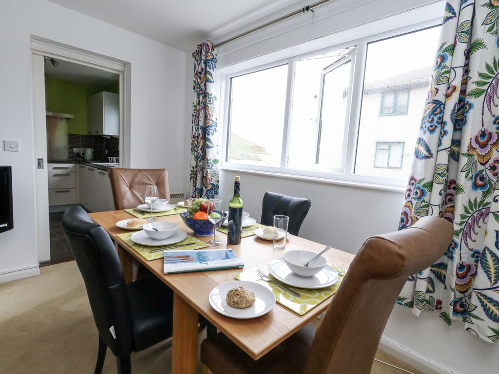 A dining room with a table set for a meal at Flat 13, Chesil House Bridport
