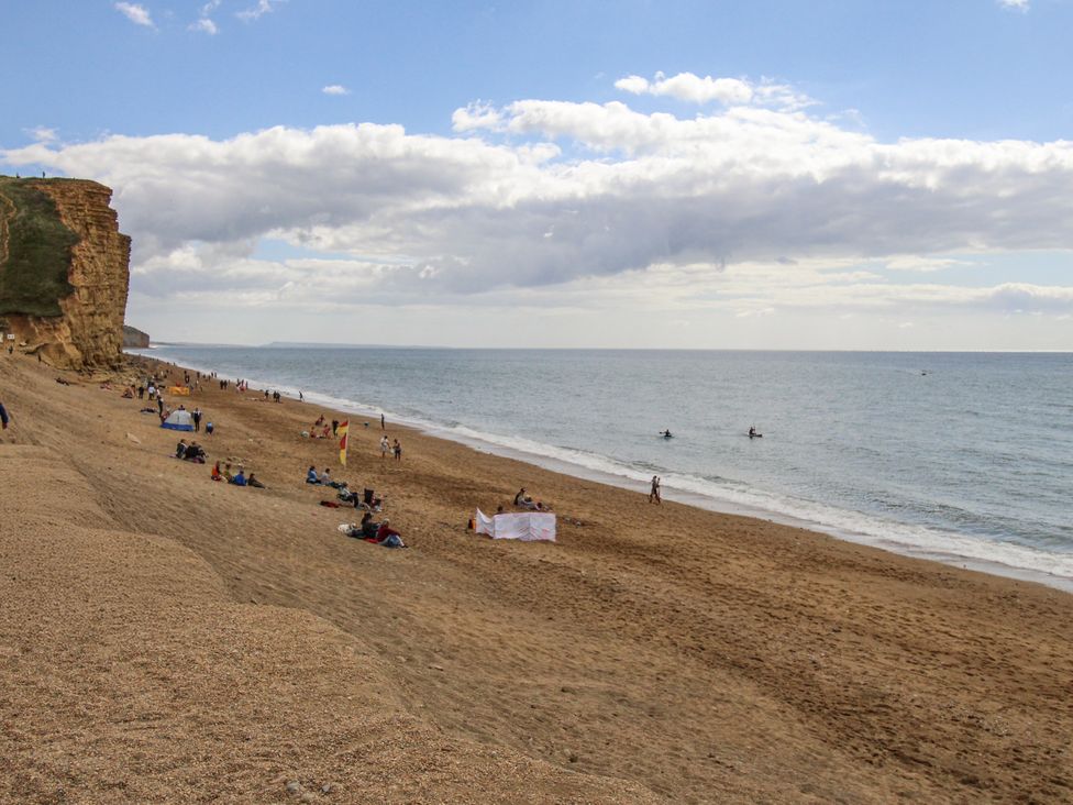 A beach with people relaxing and surfing at Flat 13, Chesil House in Bridport