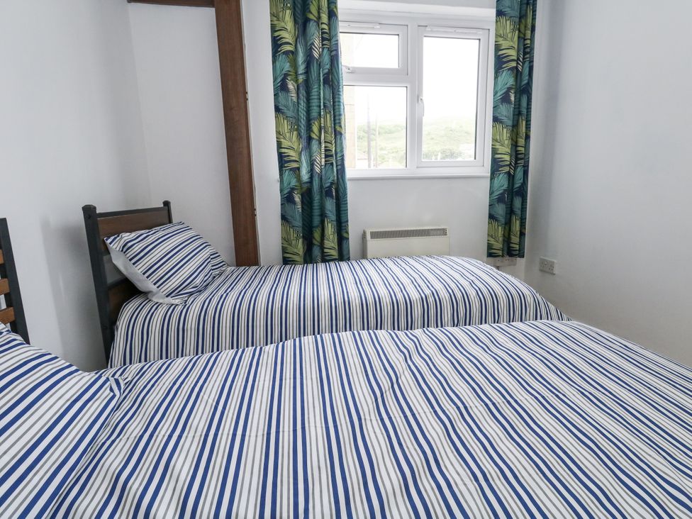 A bedroom with two beds and a window at Beachcombers, 13 Chesil House in Bridport