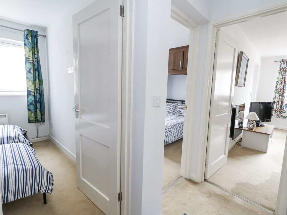 A hallway with doors leading to bedrooms at Beachcombers, 13 Chesil House in Bridport