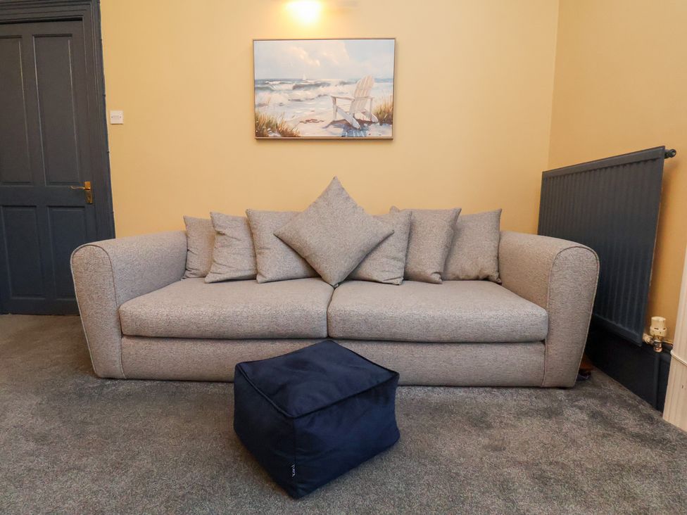 A living room with a sofa and cushions at Kingfisher House in Saltburn-by-the-Sea