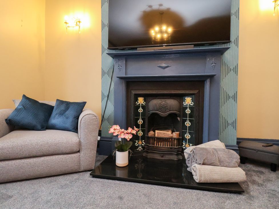 A living room with a sofa and fireplace at Kingfisher House Saltburn-by-the-Sea