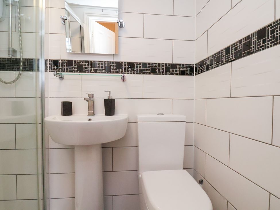 A bathroom with a sink, toilet and shower at Kingfisher House Saltburn-by-the-Sea