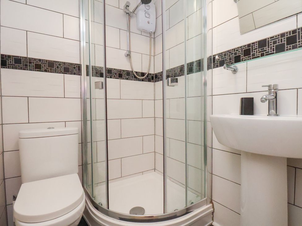 A bathroom with a shower, toilet and washbasin at Kingfisher House Saltburn-by-the-Sea