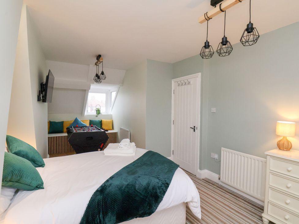 A bedroom with a bed and a foosball table at Kingfisher House Saltburn-by-the-Sea
