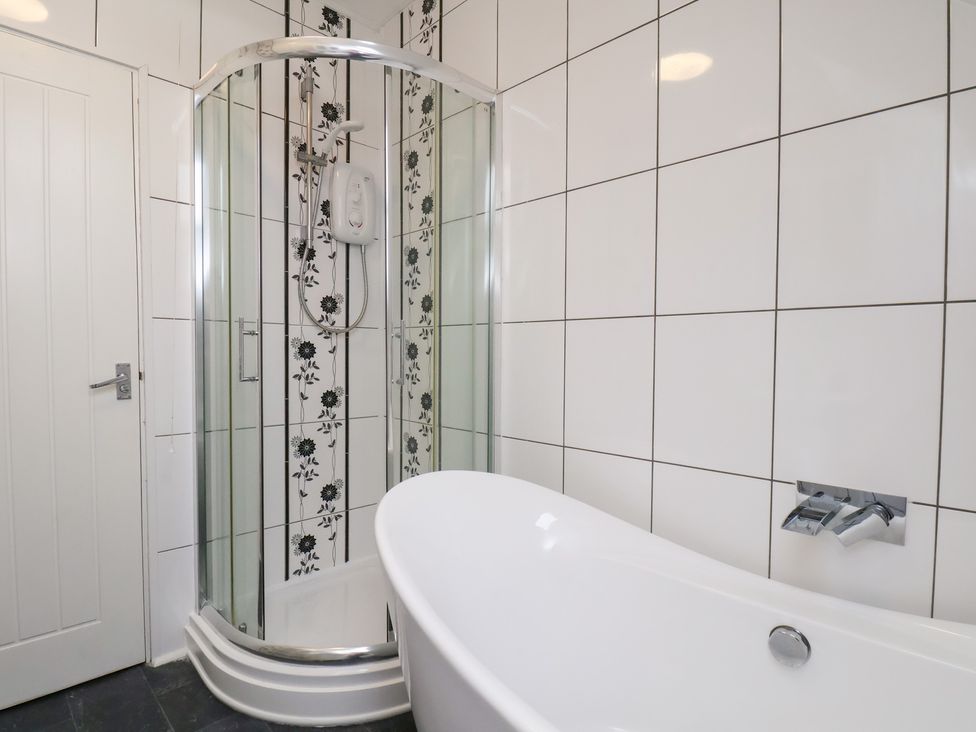 A bathroom with a shower and bathtub at Kingfisher House Saltburn-by-the-Sea