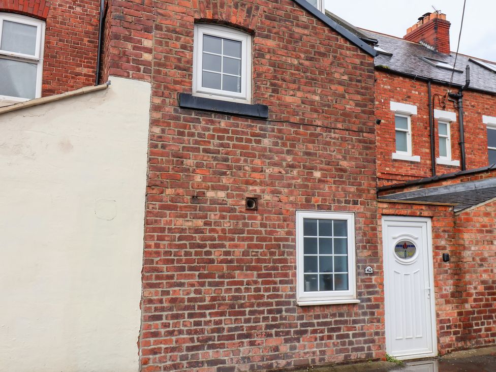 An exterior view of a brick house with windows and a door at Kingfisher House in Saltburn-by-the-Sea