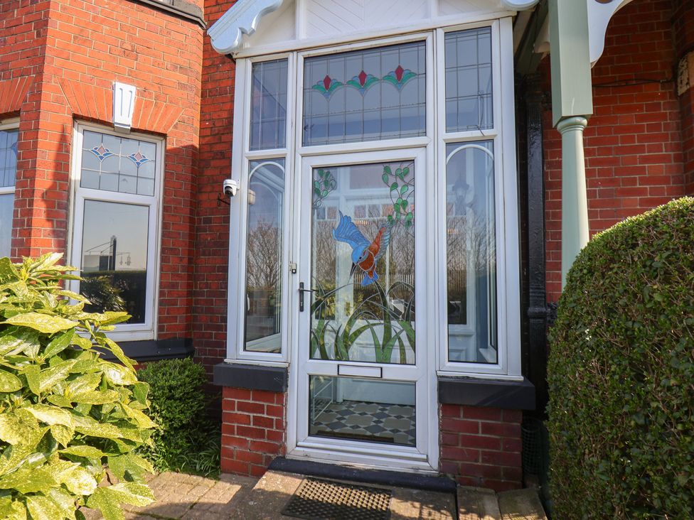 An entrance with a stained glass door and plants at Kingfisher House in Staithes