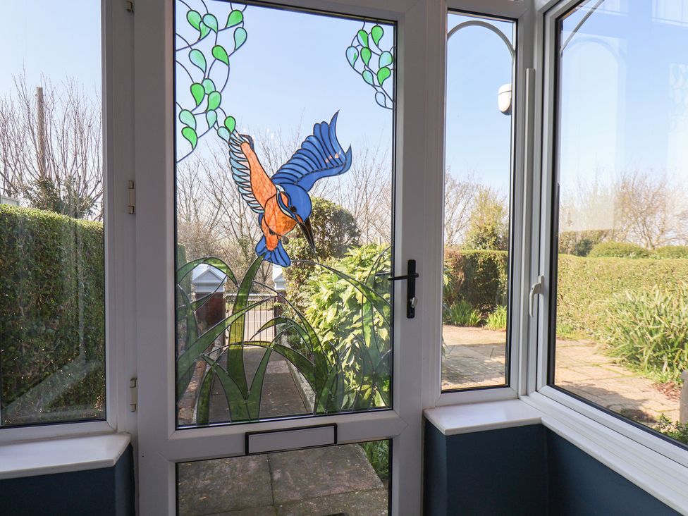 A stained glass window with a bird at Kingfisher House in Staithes