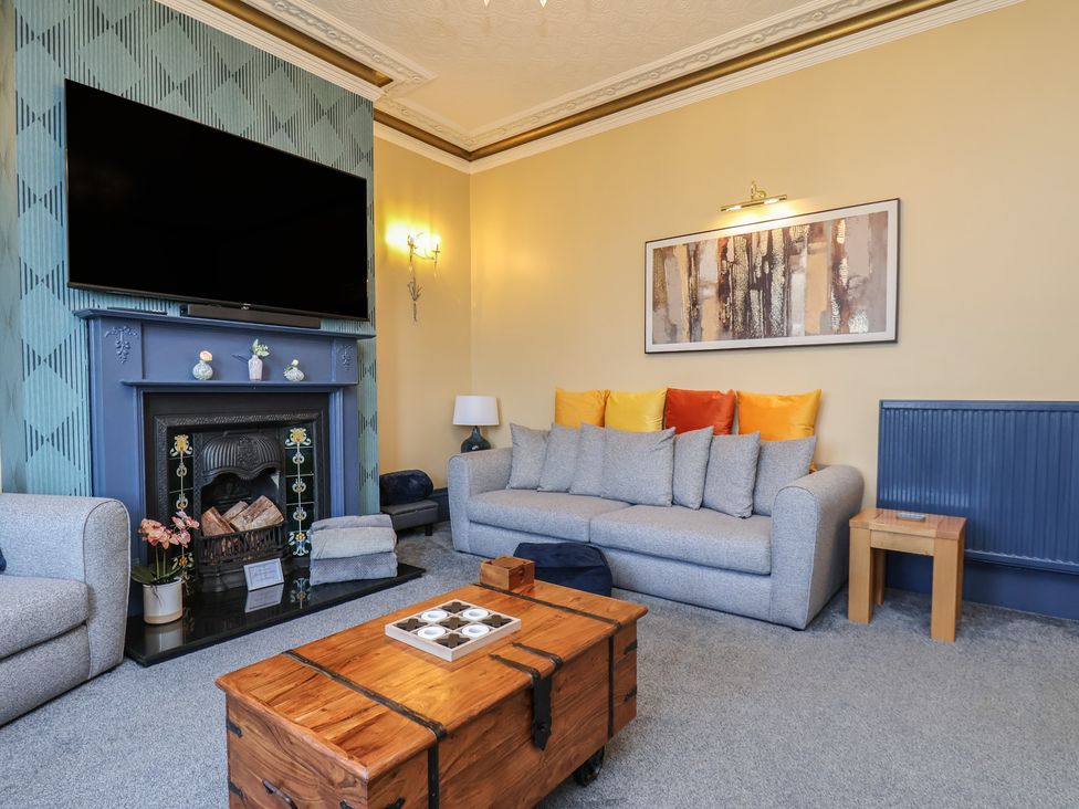 A living room with a television and sofa at Kingfisher House in Staithes