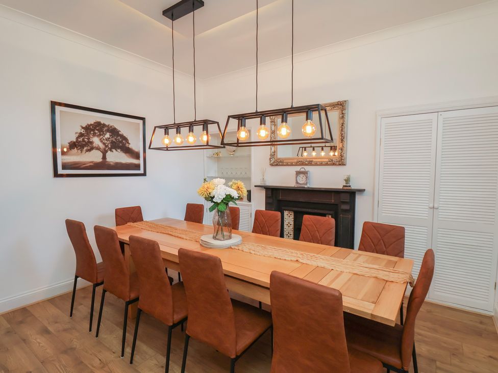 A dining room with a wooden table and chairs at Kingfisher House in Staithes