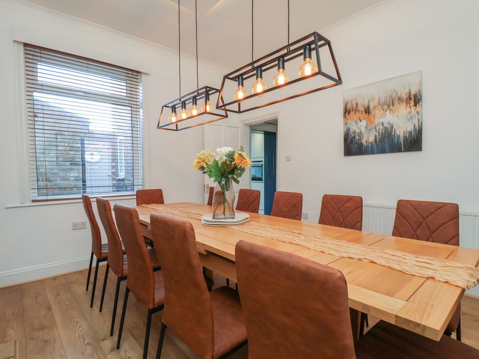 A dining room with a large table and chairs at Kingfisher House in Staithes