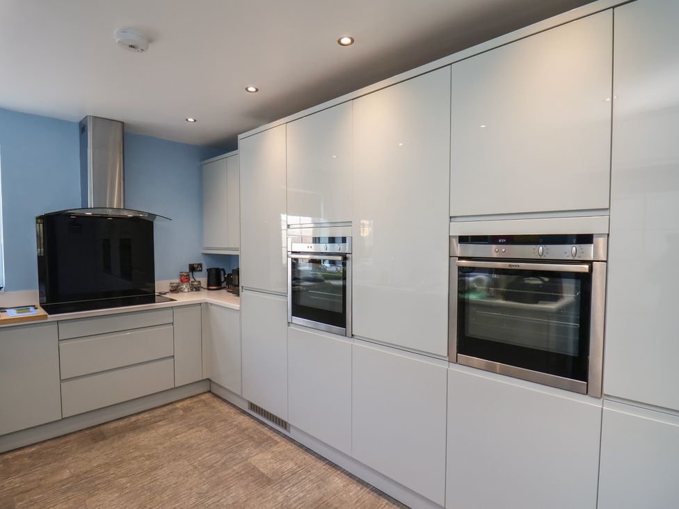 A kitchen with integrated appliances and modern cabinetry at Kingfisher House in Staithes