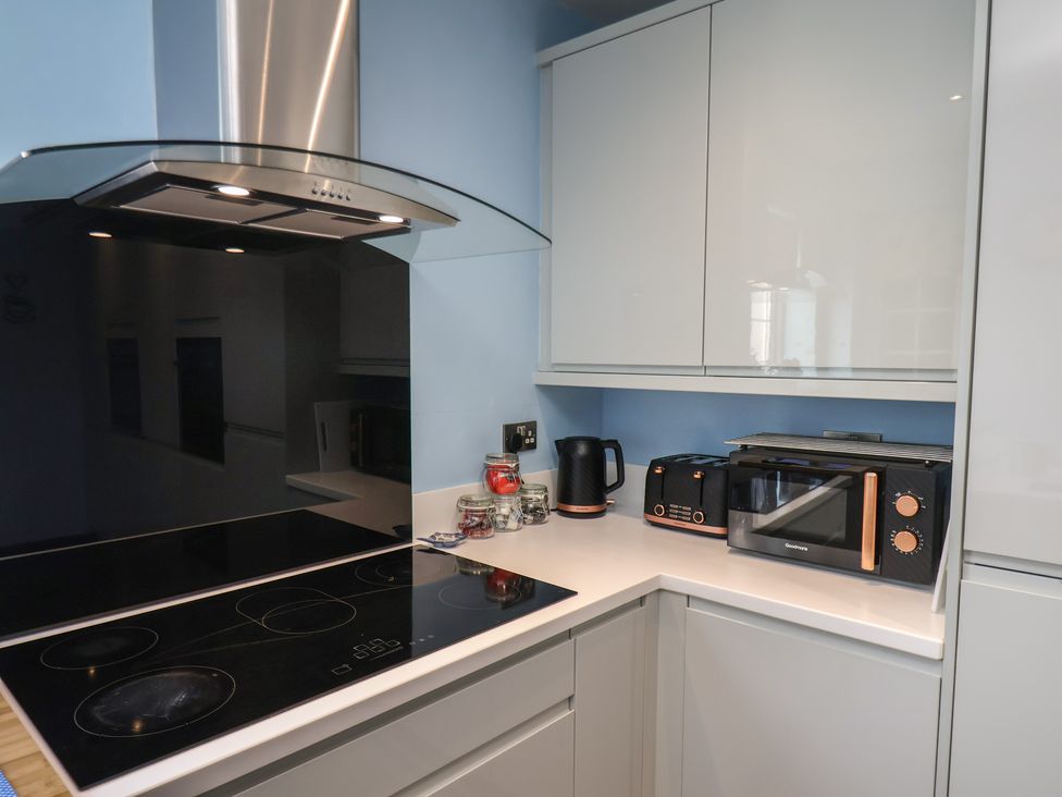 A kitchen with a stove and microwave at Kingfisher House in Staithes
